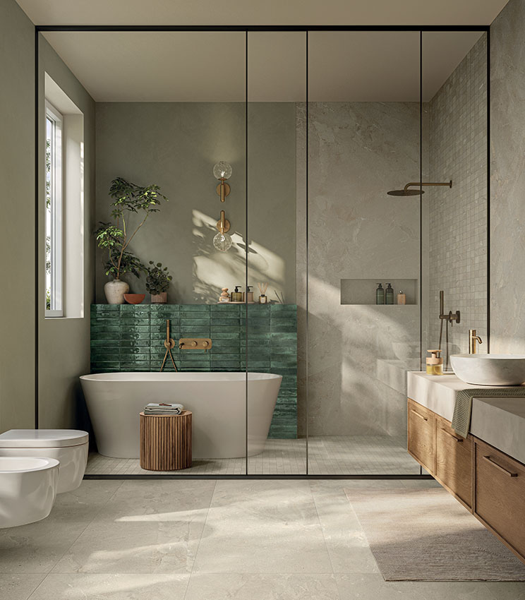 Bagno contemporaneo con superfici delle collezioni Revel Dune, Mosaico Dune e Workshop Jade, caratterizzato da una vasca freestanding, parete verde lucida, ampia doccia in vetro, mobile lavabo in legno e luce naturale che illumina le superfici dai toni neutri.