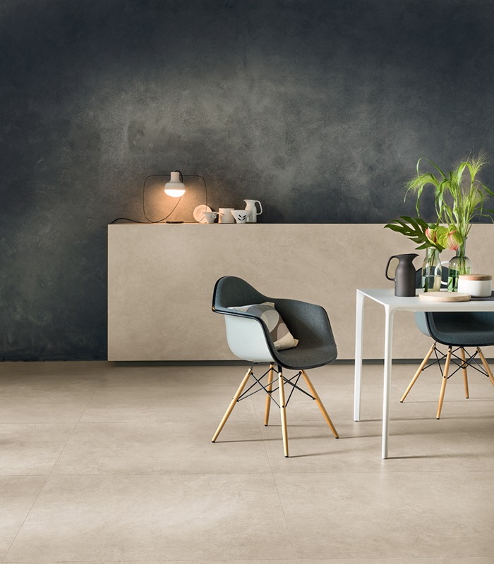 Interno moderno con pavimento in gres porcellanato effetto cemento, pareti scure e arredi minimalisti in stile nordico.