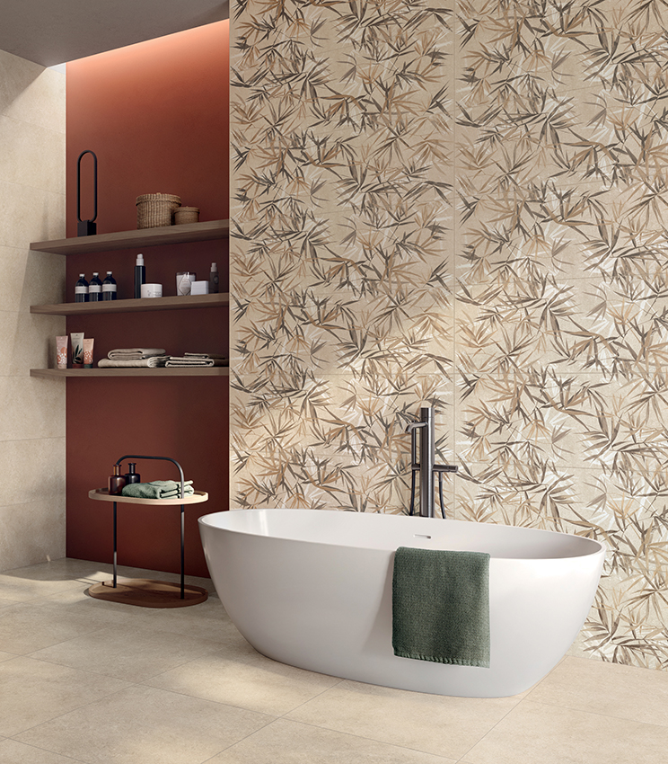 Bagno contemporaneo con vasca freestanding, rivestito con superfici della collezione Iqoniqa di Panaria Ceramica: il decoro botanico Stalks Warm caratterizza la parete principale, abbinato alle tonalità neutre di Velvet Naturale su pavimento e pareti.