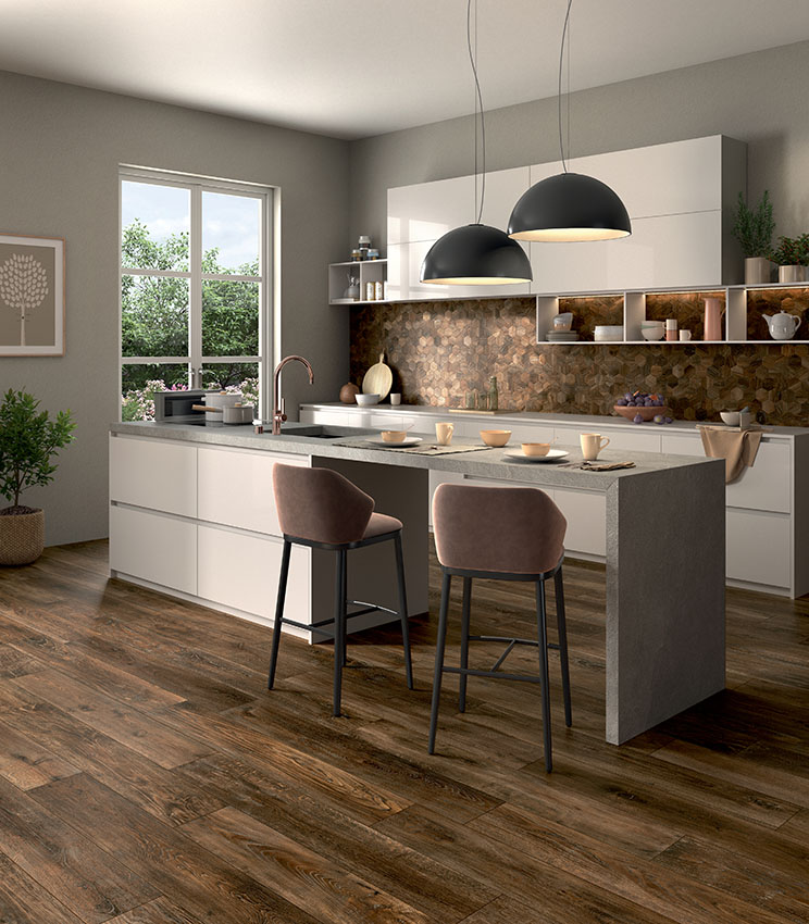 Cucina bianca moderna con isola dinette, pavimento in doghe scure di gres porcellanato effetto legno e backsplash in mosaico ceramico esagonale coordinato