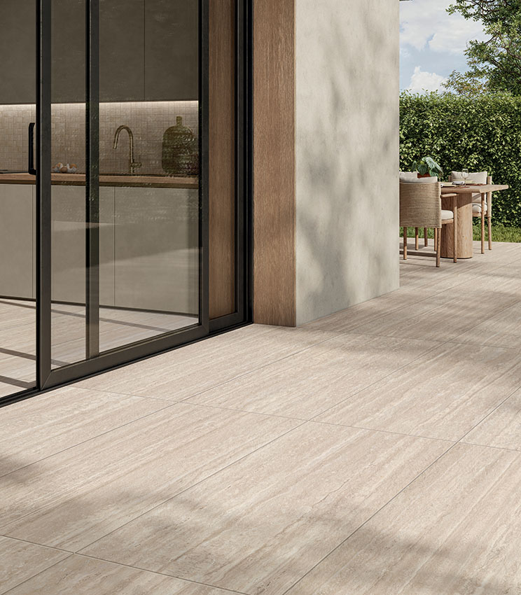 Interno cucina con pavimento in gres effetto travertino Perpetual Travertino di Panaria Ceramica, in continuità con l’outdoor.