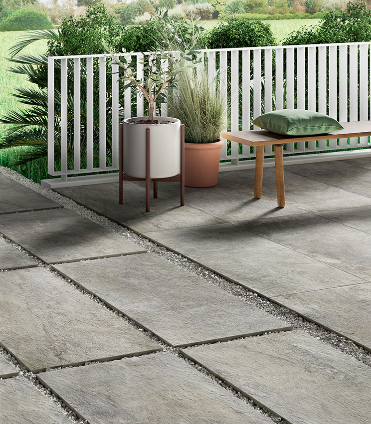 Scorcio di pavimentazione esterna in gres porcellanato effetto pietra in 20 mm di spessore, in parte terrazzo (con posa a colla) e in parte camminamento, con posa a secco su ghiaia | Collezione Pierre Des Reves di Panaria Ceramica