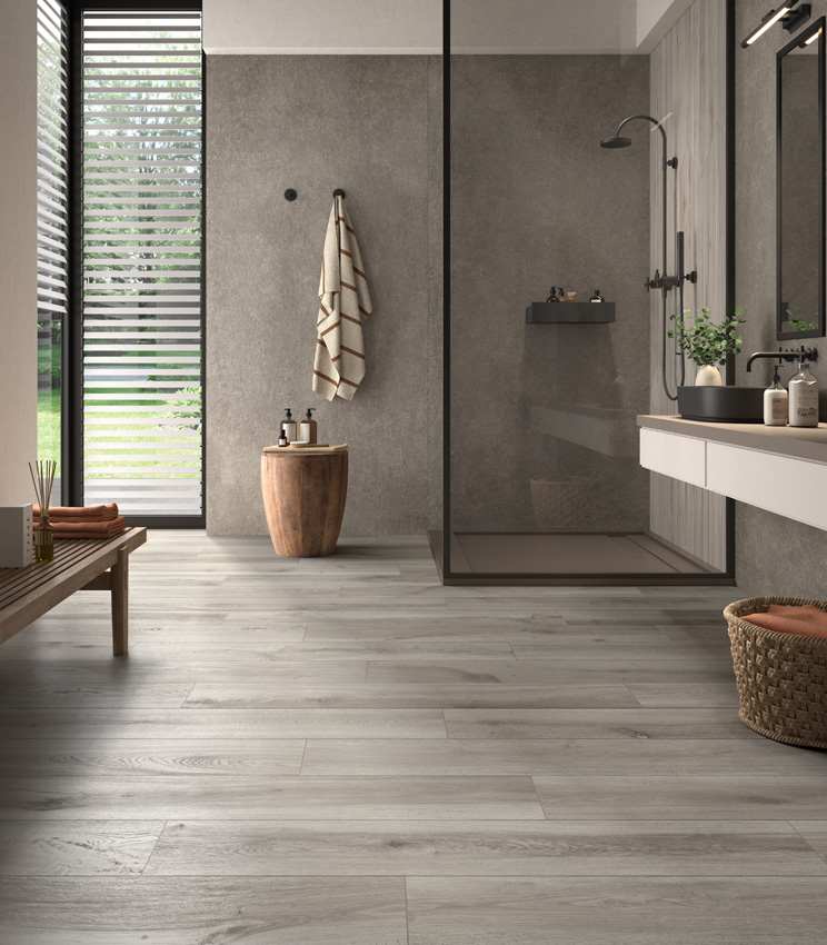 Moderno bagno con angolo vetrato sulla sinistra e lavabo sulla destra, doccia frontale rivestita in gres effetto pietra grigio e pavimento in doghe di legno ceramico grigio.